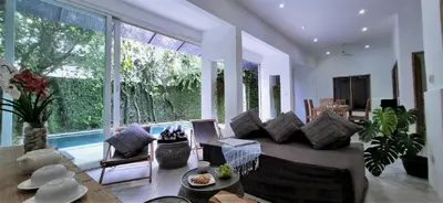 a living room with a couch and a large window at Tropical 2br private pool Villa in central Seminyak in Seminyak