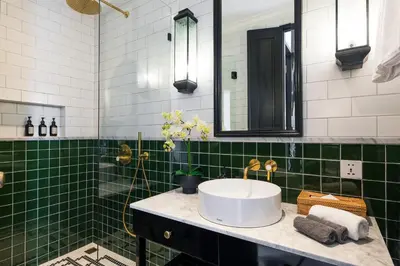 a bathroom with a sink and green tiles at Martini Beachside Villa 7 in Canggu