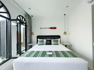 a bedroom with a large bed and a window at Martini Beachside Villa 7 in Canggu