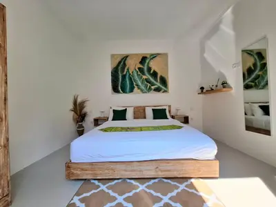 a bedroom with a large bed with white sheets at Villa A La Cool Seminyak in Seminyak