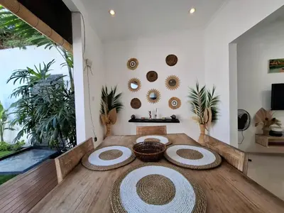 a dining room with a table with large circular mats at Villa A La Cool Seminyak in Seminyak
