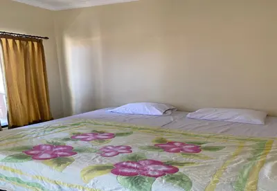 a bed with a blanket with flowers on it at Hotel Near Beach Ayu inn Kuta in Kuta