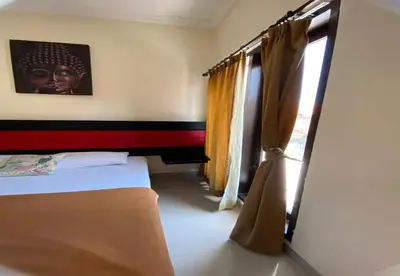 a bedroom with a bed and a window with curtains at Hotel Near Beach Ayu inn Kuta in Kuta
