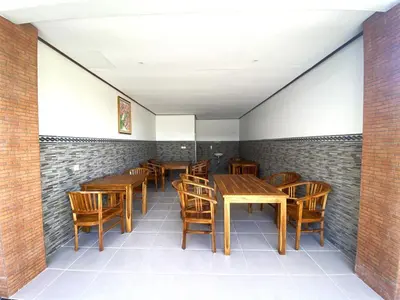 a dining room with wooden tables and chairs at Bidadari Homestay Nusa Dua in Nusa Dua