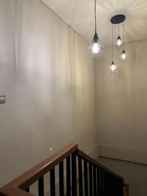 a room with a staircase with lights on the wall at Kubu Gandi Homestay in Denpasar