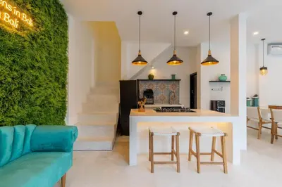 a kitchen and living room with a green wall at Aaryan Villa 1 in Seminyak