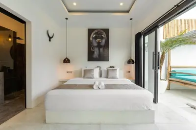 a bedroom with a large white bed in a room at Aaryan Villa 1 in Seminyak