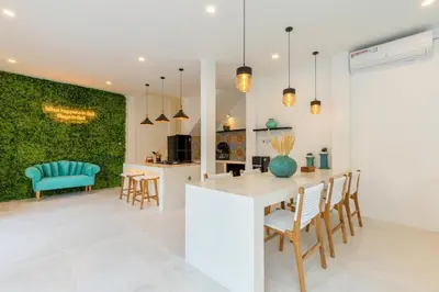a kitchen and dining room with a green wall at Aaryan Villa 1 in Seminyak