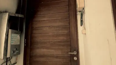 a brown door in a room next to a wall at kerobokan cozy house by kenta in Seminyak