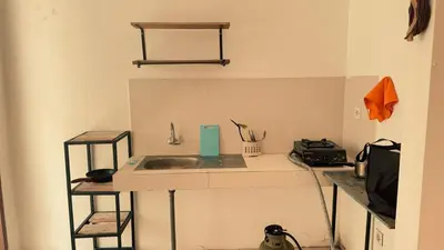 a kitchen with a sink and two shelves at kerobokan cozy house by kenta in Seminyak