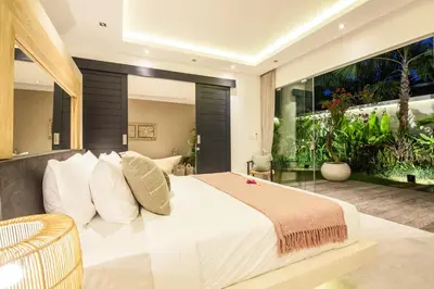 a bedroom with a large bed and an aquarium at Villa Hugo in Canggu