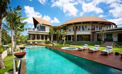 a villa with a swimming pool and a house at Umah Daun by Nakula in Canggu