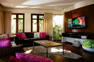 a living room with a couch and a tv at Umah Daun by Nakula in Canggu