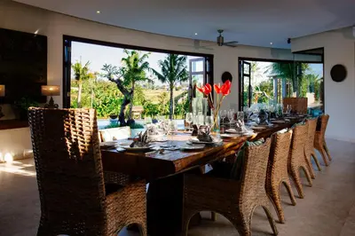a long dining room with a long table and chairs at Umah Daun by Nakula in Canggu