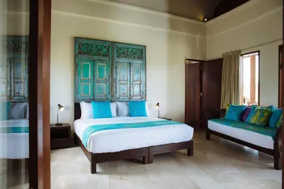 a bedroom with two beds with blue and white at Umah Daun by Nakula in Canggu