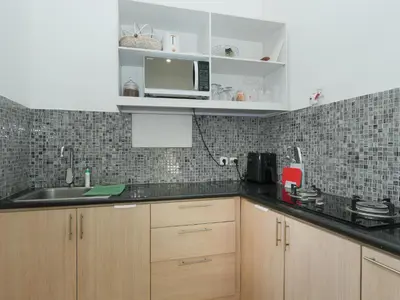a kitchen with a sink and a microwave at The White House Villa Taeyvela Seminyak in Seminyak