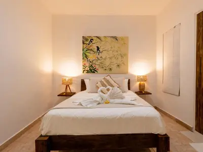 a bedroom with a bed with a towel on it at The White House Villa Taeyvela Seminyak in Seminyak