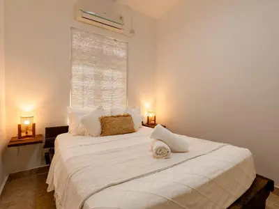 a bedroom with a large white bed with a window at The White House Villa Taeyvela Seminyak in Seminyak