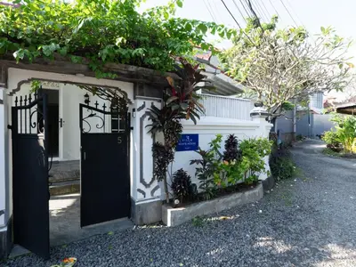 a house with a black door and some plants at The White House Villa Taeyvela Seminyak in Seminyak