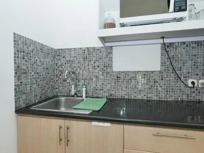 a kitchen counter with a sink and a microwave at The White House Villa Taeyvela Seminyak in Seminyak