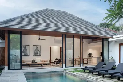 a villa with a swimming pool and a house at Villa Under the Sun - Seminyak in Seminyak