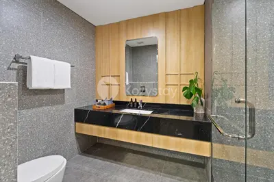 a bathroom with a sink and a glass shower at Rivana by Kozystay - Nusa Dua in Nusa Dua