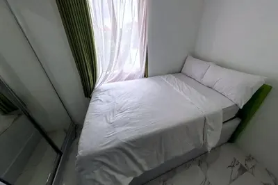 a small bed in a small room with a window at Villa 9 in Seminyak