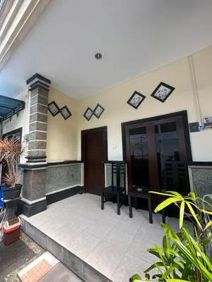 a porch of a house with a door and chairs at OSA Guest House in Seminyak