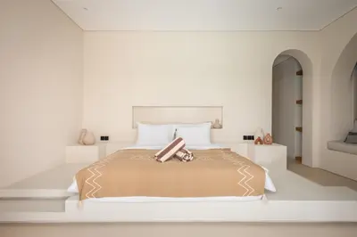 a white bedroom with a large bed with brown blanket at Brand New Exquisite Luxury 5 BR Villa Umalas in Kerobokan