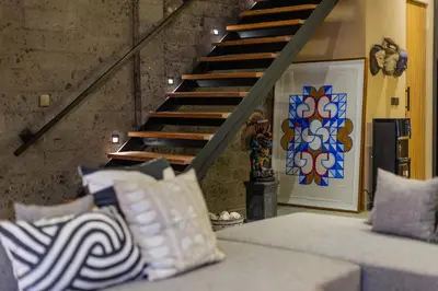 a living room with a couch with pillows and a staircase at DUNE ARRAKIS villas in Seminyak