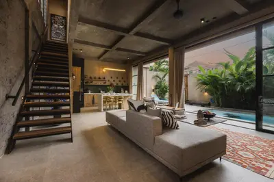 a living room with a couch and a staircase at DUNE ARRAKIS villas in Seminyak
