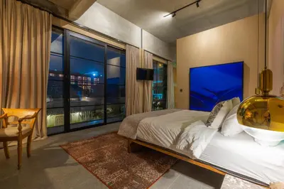 a bedroom with a large bed and a large window at DUNE ARRAKIS villas in Seminyak