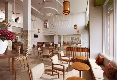a restaurant with tables and chairs and a lobby at Diamond Hotel Kuta Bali in Kuta