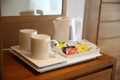 a table with two cups and a tray of food at Diamond Hotel Kuta Bali in Kuta