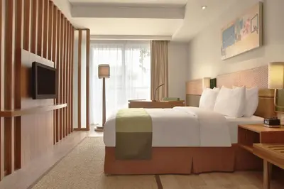 a hotel room with a bed and a television at Diamond Hotel Kuta Bali in Kuta
