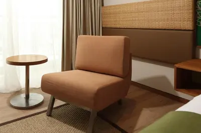a room with a chair and a small table at Diamond Hotel Kuta Bali in Kuta