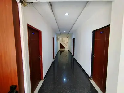 a corridor of an office building with two doors at Easton Homestay in Ngurah Rai International Airport