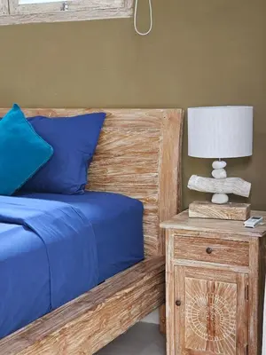 a bedroom with a bed and a nightstand with a lamp at Villa Ohana 2 BR Family villa with pool in Umalas in Kerobokan