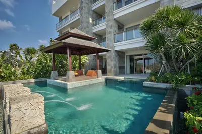 a swimming pool with a gazebo in front of a building at Luxury Apartment at AYANA Residences in Jimbaran