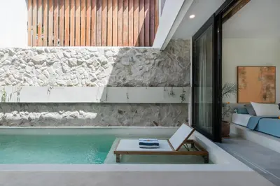 a room with a pool and a couch and a table at Villa Kanan Seminyak - Stylish 2BR Villa Private Pool in Seminyak
