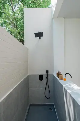 a bathroom with a bath tub with a shower at Villa Kanan Seminyak - Stylish 2BR Villa Private Pool in Seminyak