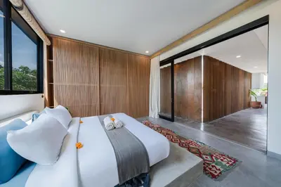 a bedroom with a large bed and large windows at Villa Kiri - Modern 2BR Hideaway Rooftop & Private Pool in Seminyak