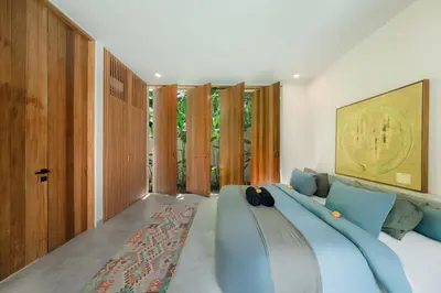 a bedroom with a blue bed in a room with windows at Villa Kiri - Modern 2BR Hideaway Rooftop & Private Pool in Seminyak