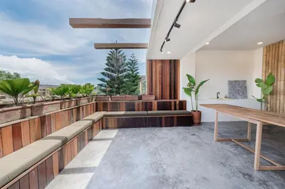 a balcony with a wooden bench and a table at Villa Kiri - Modern 2BR Hideaway Rooftop & Private Pool in Seminyak