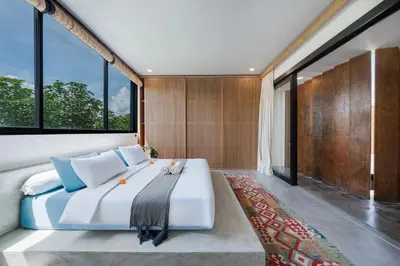 a bedroom with a large white bed and large windows at Villa Kiri - Modern 2BR Hideaway Rooftop & Private Pool in Seminyak