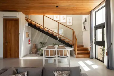 a living room with a table and a staircase at Ben's Villa 2 by Alfred in Bali in Kerobokan