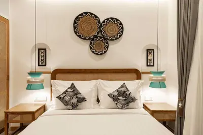 a bedroom with a bed with two tables and a clock on the wall at Ben's Villa 2 by Alfred in Bali in Kerobokan