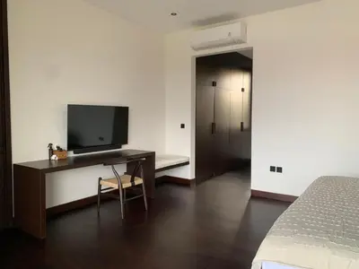 a bedroom with a desk with a television and a bed at Villa Gendang in Seminyak