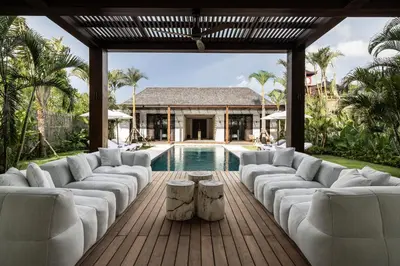 a living room with white furniture and a swimming pool at Villa Gendang in Seminyak