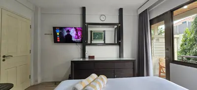 a bedroom with a bed and a tv on the wall at The Palmana Tropical Courtyard Jayakarta Residence 12 in Seminyak